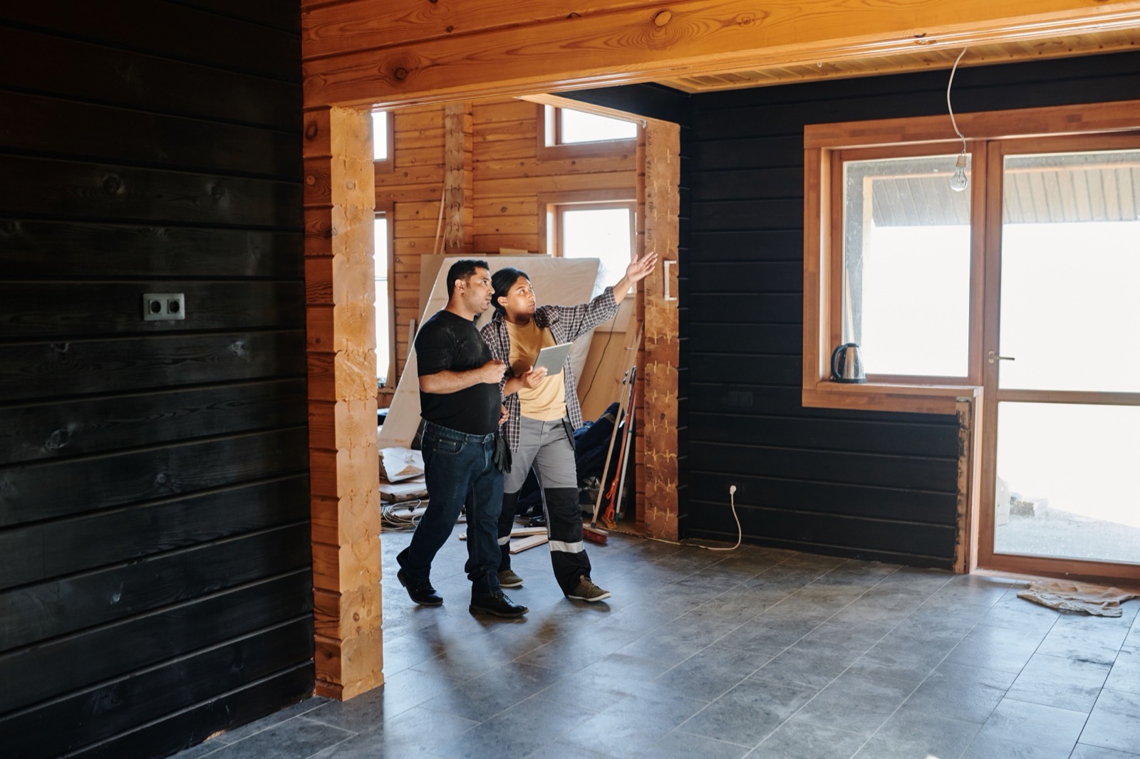 Akin on site measuring up and discussing the job with a homeowner