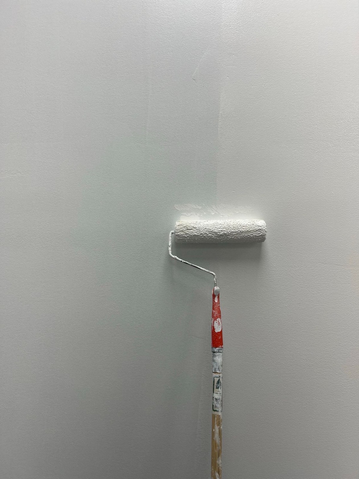 Close-up of a decorator rolling flat, even paint onto an interior wall