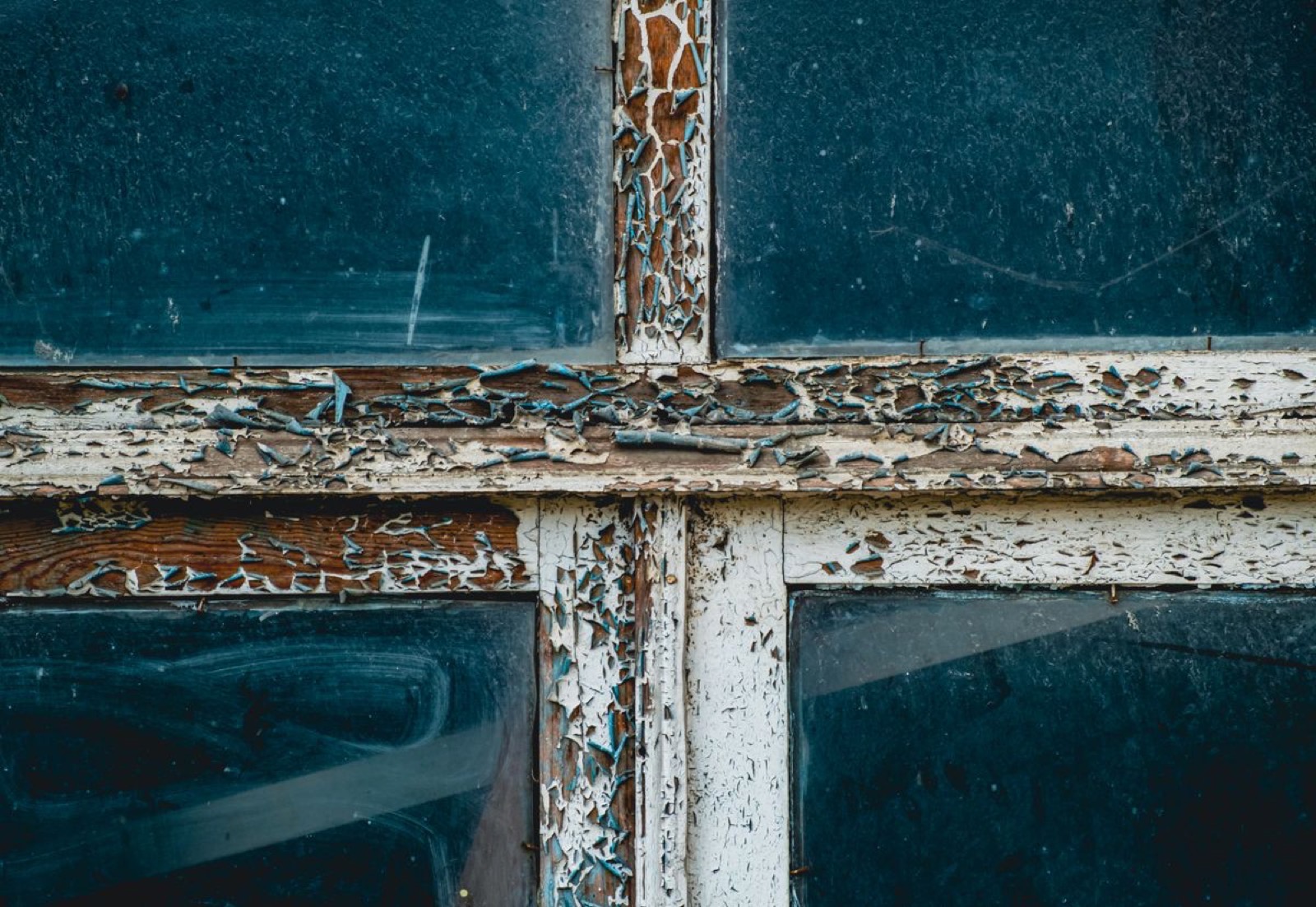 Close-up of a window frame with old paint badly cracked and peeling, before stripping